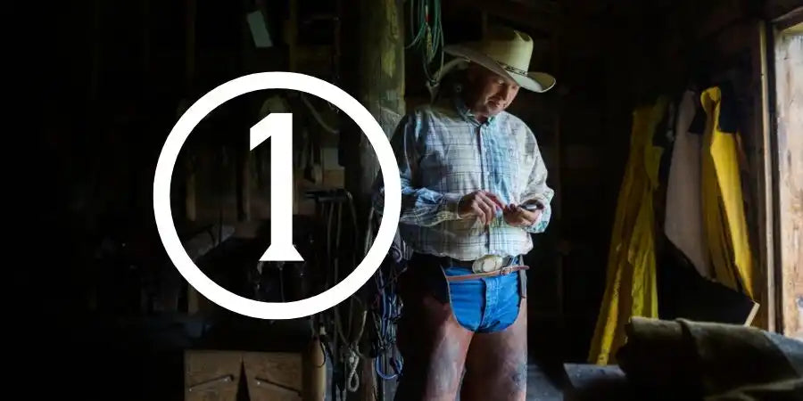 Cowboy hat with blue band and silver buckle, leather material.