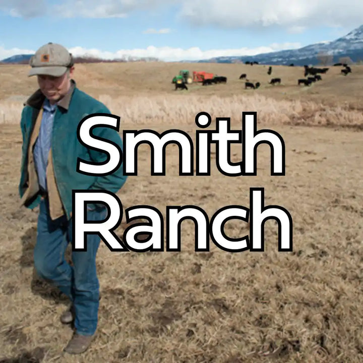 Green denim jacket with brown leather collar and buttons, worn over blue shirt and khaki pants.assistant: smith ranch cowboy hat in tan fabric with dark band.