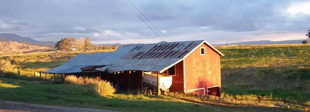Red barn with metal roof and weathered siding, rustic charm.
